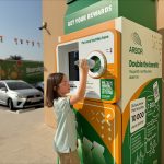 Photo of an Arbor student recycling a bottle into a mahine